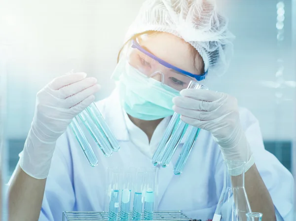 Asyalı kadınlar bilim adamı ile test tüpü içinde klinik laboratuvar araştırma yapma. Bilim, kimya, teknoloji, biyoloji ve insanlar kavramı