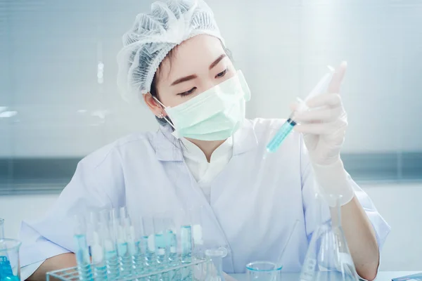 Asyalı kadınlar bilim adamı ile test tüpü içinde klinik laboratuvar araştırma yapma. Bilim, kimya, teknoloji, biyoloji ve insanlar kavramı
