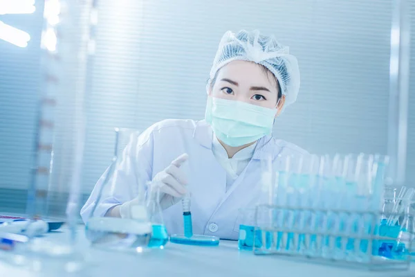 Asyalı kadınlar bilim adamı ile test tüpü içinde klinik laboratuvar araştırma yapma. Bilim, kimya, teknoloji, biyoloji ve insanlar kavramı