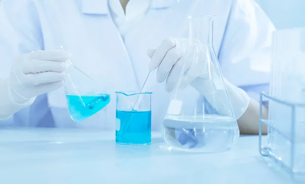 科学家手握瓶 用化学液体滴入试管 科学与医学研究与发展理念 免版税图库照片