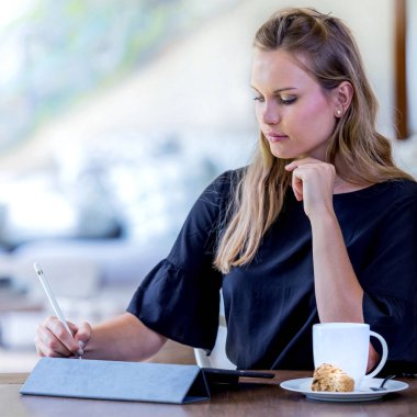 Bir kafede bir yastık aygıtta çalışan kadınlar.