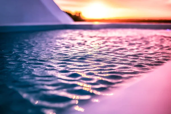 太陽と太陽光を反射するプールの水がダウンします 夕暮れ時のプールの水の波紋 — ストック写真
