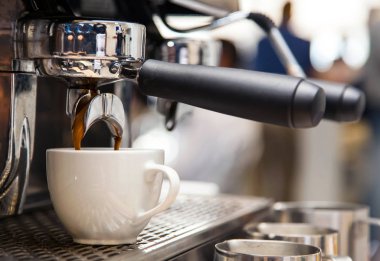 Kahve fincan içine kafede barista makineden gidiş kapatın. Americano yapılıyor.