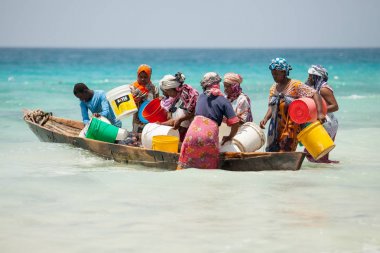 Stone Town, Zanzibar, Tanzanya, Mayıs 28-2015: kova ile küçük balıklar teknenin gövde toplama kadınlar.