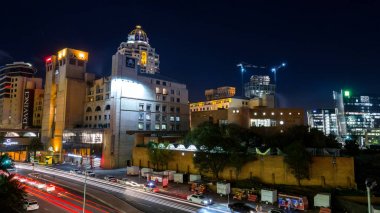 Johannesburg, Güney Afrika, Nisan 6-2018: Cityscape aydınlatılmış binalar ve ön planda trafik ile gece.