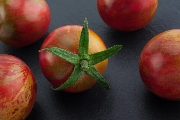 Brown cherry tomatoes colseup isolated on black background