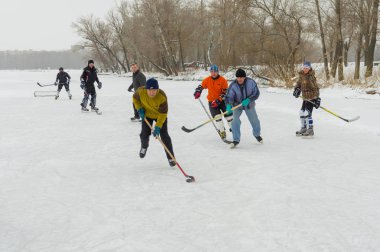 Dnipro, Ukrayna - 28 Ocak 2018: Ukrayna 'da donmuş bir nehirde hokey oynayan bir grup farklı yaşlı insan