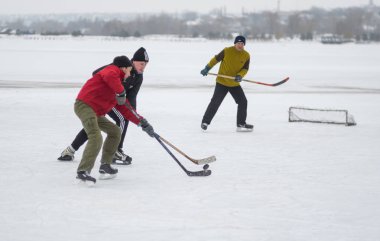 Dnipro, Ukrayna - 28 Ocak 2018: Genç kavga Pak için olgun adamla donmuş nehir Dnipro Ukrayna'daki Tarih hokey oynarken adam