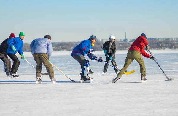 Dnepr, Ukraine - January 22, 2017: Group of different ages people playing hockey on a frozen river Dnepr in Ukraine