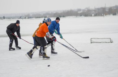 Dnipro, Ukrayna - 28 Ocak 2018: Ukrayna 'da donmuş bir nehirde hokey oynayan bir grup farklı yaşlı insan