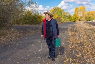 Komuta sizde bir ülke yolda duran ve eski bir yeşil çanta koşullarının baston ile