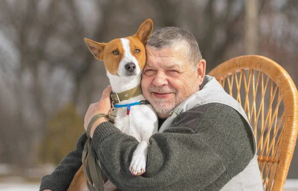 Açık beyaz komuta sizde güneşli gün hasır koltuğunda oturmak sevimli alçaklık köpeğiyle portresi