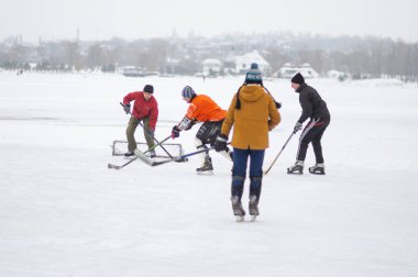 Dnipro, Ukrayna - 28 Ocak 2018: Ukrayna 'da donmuş bir nehirde hokey oynayan aktif farklı yaş ve cinsiyet grupları