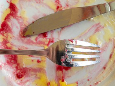 Öğle yemeğinden sonra çatal ve bıçakla boş tabakta en üstteki manzara. 