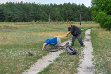 Senior man punishing thief who driven away his ancient bicycle in Ukrainian rural area clipart