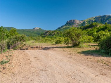 Hayaletler Vadisi 'ne giden toprak yollu bahar manzarası Kırım dağlarında yürüyüş için güzel bir yer.