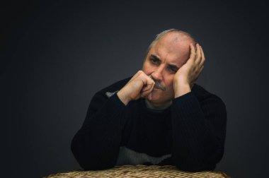 Nazik, beyaz, gösterişsiz, olgun bir adamın portresi.
