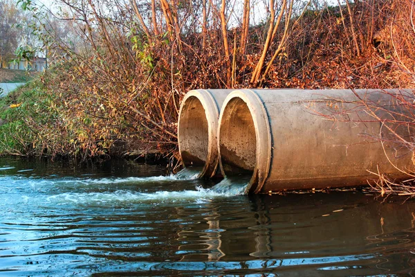 Utsläpp av avloppsvatten i en flod — Stockfoto