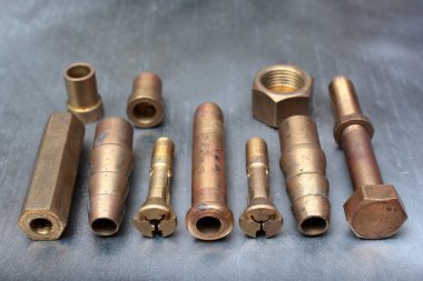 Çelik arka planda pirinç cıvatalar, vidalar ve montajlar