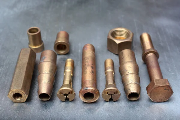 Çelik arka planda pirinç cıvatalar, vidalar ve montajlar