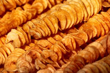 Şişte sarı muz cipsi, sokak yemekleri arka planı.