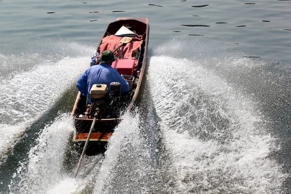 Человек в длинной хвостовой лодке, Таиланд — стоковое фото