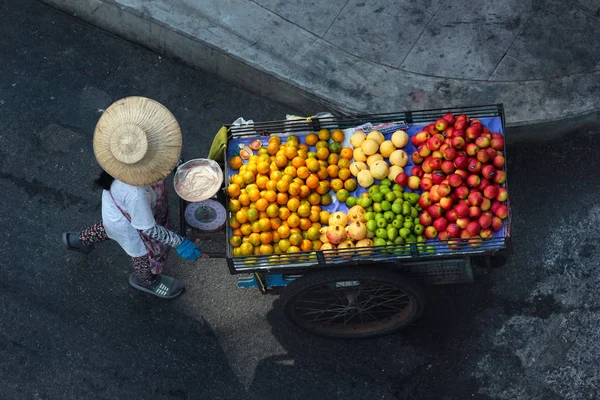 Street fruit vendor pushes her wheelbarrow in Phaya Thai district of Bangkok. — Stock Photo, Image