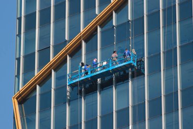 Bangkok, Tayland - 11 Aralık 2019: Bahar Kulesi 'nden iple inen pencere temizleyicileri, Bangkok' un merkezindeki modern bir özel ofis binası.
