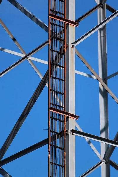 青い空に対する電気通信タワー上の電力と信号ケーブル — ストック写真