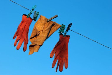 Mavi gökyüzü arkaplanındaki çamaşır ipinde asılı duran tozluk.