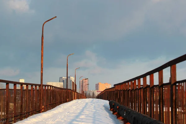 Abandoned bridge at a railway station, covered with snow at wintertime