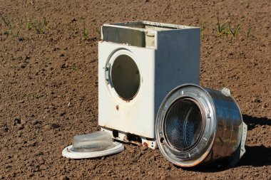 Paslanmaz çelik varili olan eski bir çamaşır makinesi leşi.