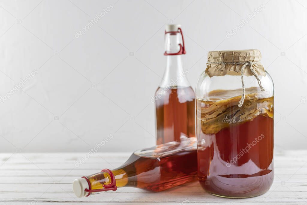 Kombucha superfood pro biotic tea fungus beverage in glass bottle and jar on white background. copy space