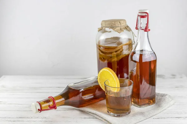 Kombucha süper yiyeceği, beyaz arka planda limonlu cam şişe ve kavanozda biyotik çay mantarı içeceği. Boşluğu kopyala