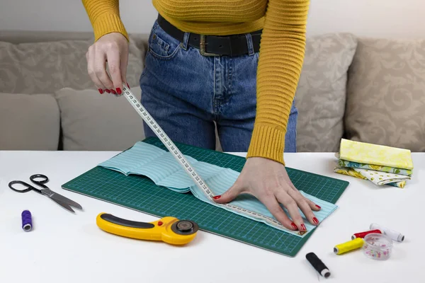 Женщина Жёлтом Свитере Измеряет Ткань Столе Лежат Инструменты Стегания Одеял — стоковое фото