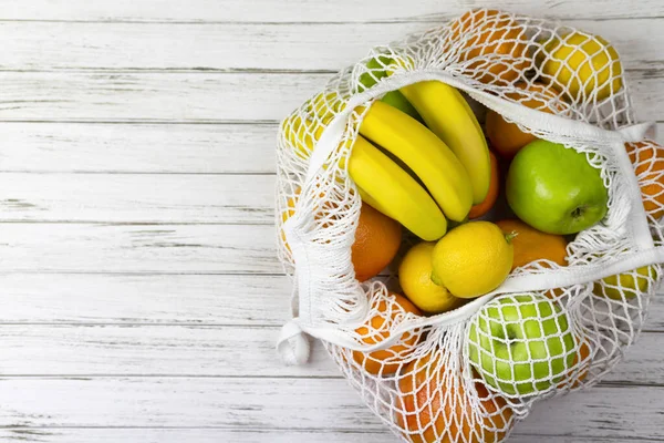 meyve armudu portakalı limon ve mantar ağları, beyaz ahşap arka planda ip alışveriş torbası. sıfır atık konsepti. Plastik yok.