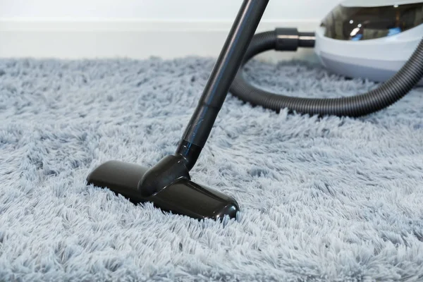 Limpeza piso tapete com aspirador de pó na sala de estar — Fotografia de Stock