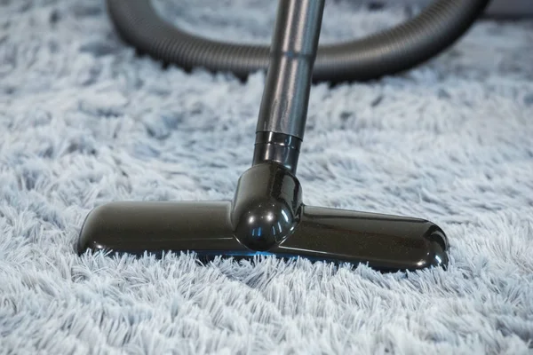 Limpeza piso tapete com aspirador de pó na sala de estar — Fotografia de Stock