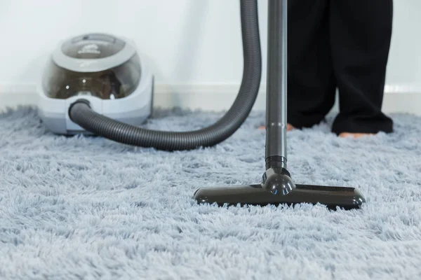 Woman cleaning carpet floor with vacuum cleaner — Stock Photo, Image