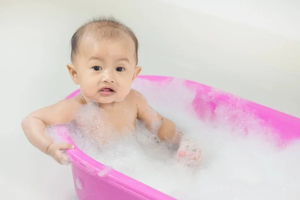 Bebé tomando un baño en la bañera y jugando con burbujas de espuma — Foto de Stock