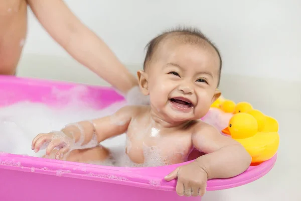 Bebé tomando un baño en la bañera y jugando con burbujas de espuma — Foto de Stock