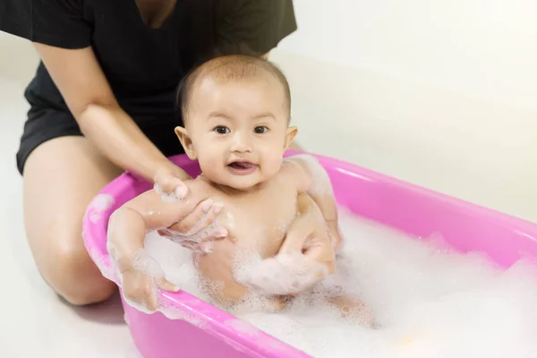 Bebé tomando un baño en la bañera y jugando con burbujas de espuma — Foto de Stock