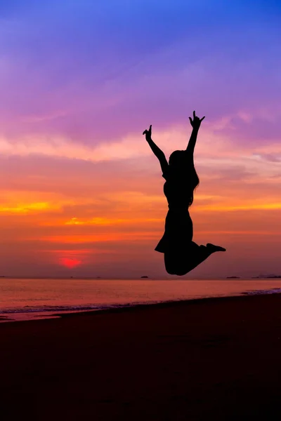 Silhouette of woman jumping with hands up and showing I LOVE YOU — Stock Photo, Image