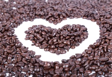 Beyaz arka planda kalp şeklinde kahve çekirdekleri.