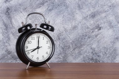 Saat 8'de vintage saat ahşap masa ve duvar arka plan üzerinde