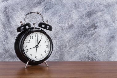 1 o'clock vintage saat ahşap masa ve duvar arka plan üzerinde
