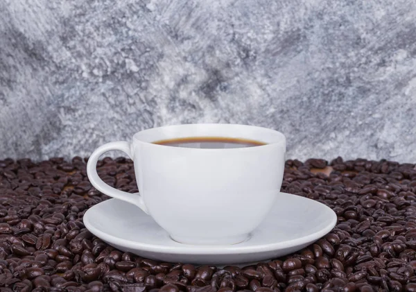 Tasse de café chaud et haricots avec mur en béton — Photo