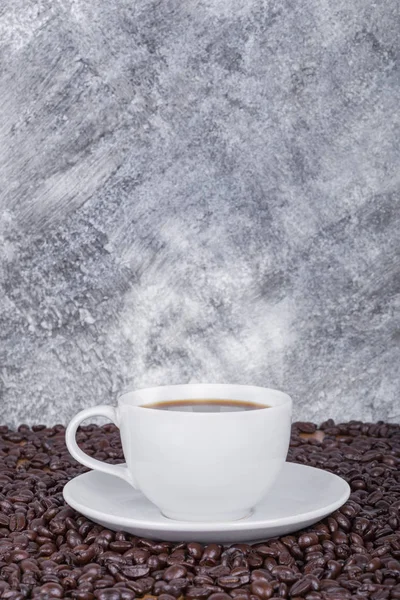 Tasse de café chaud et haricots avec mur en béton — Photo