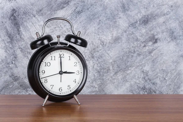 3 o'clock vintage clock on wood table and wall background