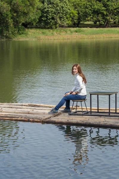 川で竹いかだに乗って座っている女性 — ストック写真